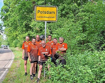 Die Waddenser Werder Buben jubeln vor dem Ortsschild von Potsdam.