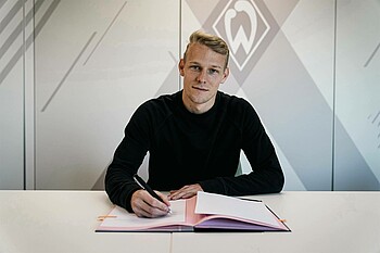 Marco Grüll signing his contract.