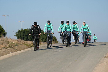 Die Mannschaft auf dem Fahrrad in der Landschaft. 