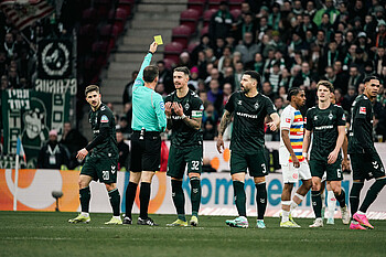Marco Friedl being shown a yellow card.