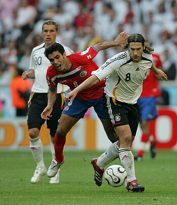 Torsten Fring mit Ball am Fuß im Zweikampf mit einem Gegenspieler. 