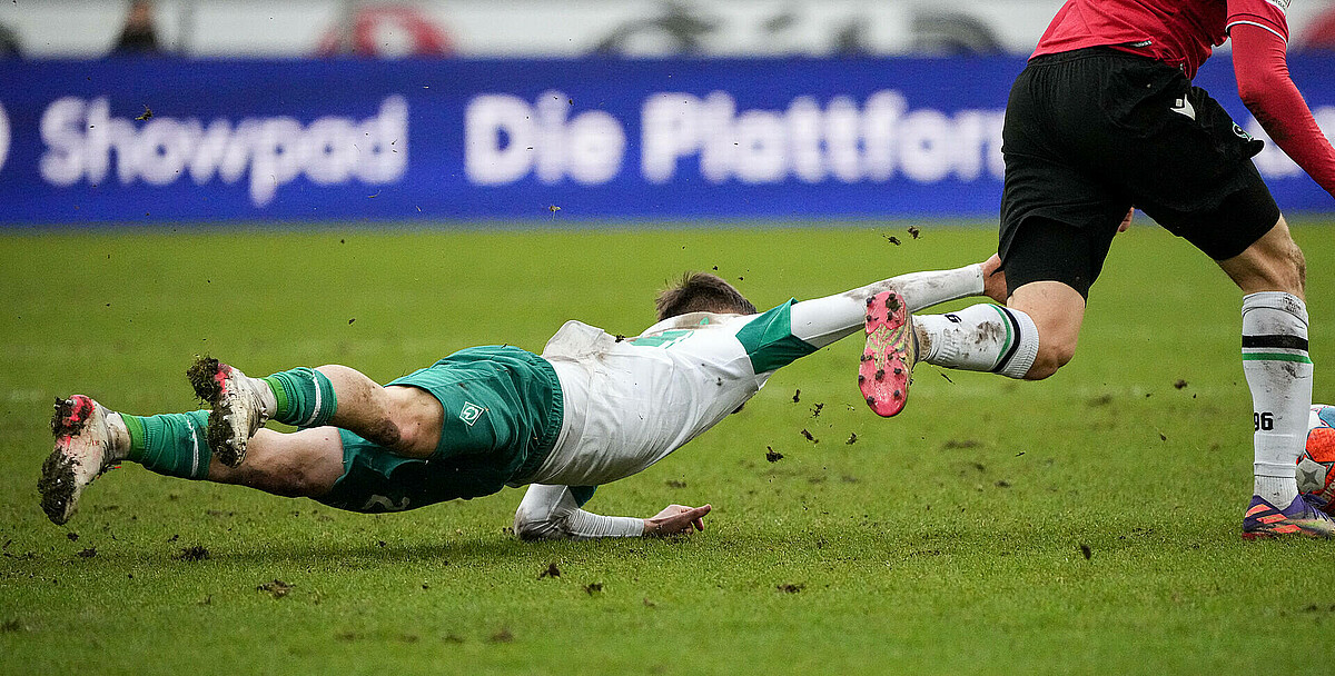 Romano Schmid fällt und scheint über dem Boden zu schweben.