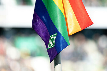 Eine Regenbogen-Eckfahne mit Werder-Logo