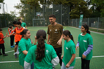 Milos Velkovic klatscht mit den Jugendlichen ab (Foto: Werder.de)