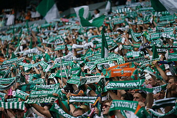 Werder-Fans in der Ostkurve halten ihren Schal hoch