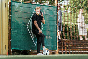 Clemens Fritz telefoniert am Rande des Trainingsplatz.