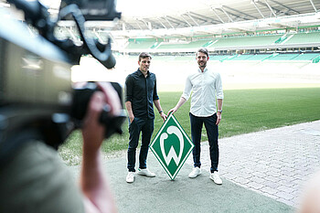 Peter Niemeyer und Clemens Fritz halten eine große Werder-Raute fest.