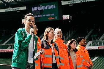 Anne Kathrin Laufmann ist zu sehen wie sie im Stadion die Helfer:innen willkommmen heißt