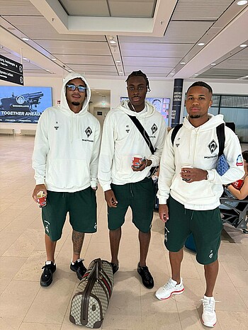 Werder players stand waiting at the airport