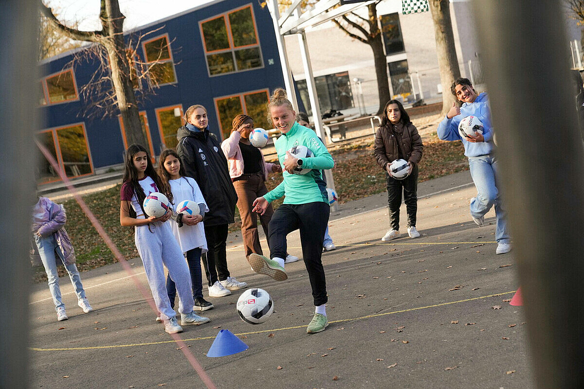 Lina Hausicke spielt mit Mädchen Fußball.