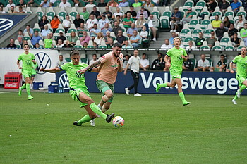 Burke challenges for the ball.