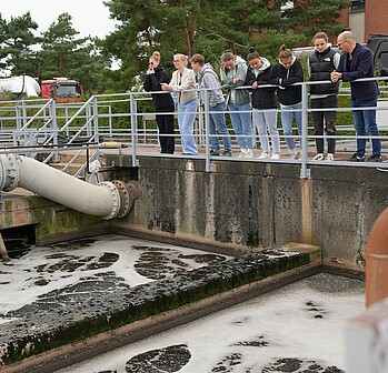 Sechs Werder-Spielerinnen blicken in ein Abwasser-Becken.