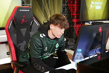 Henning sitzt konzentriert vor dem Bildschirm und spielt EAFC. 